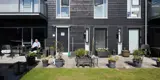 Kvinde sidder på terrasse foran sit rækkehus i boligområdet Sallingsundvej i Aalborg